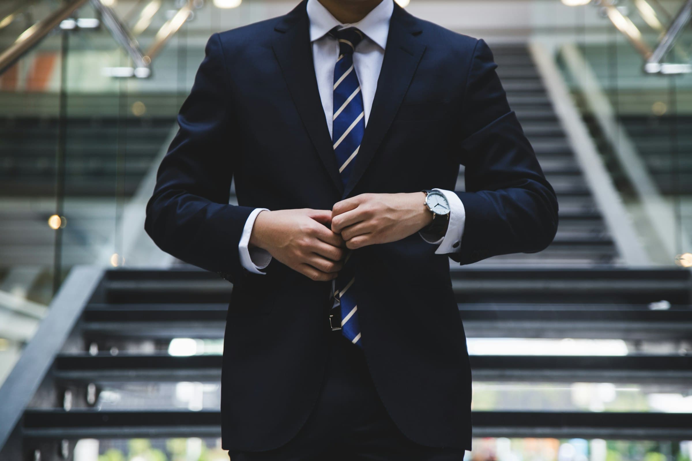 Advisor in a charcoal suit against a dark professional backdrop