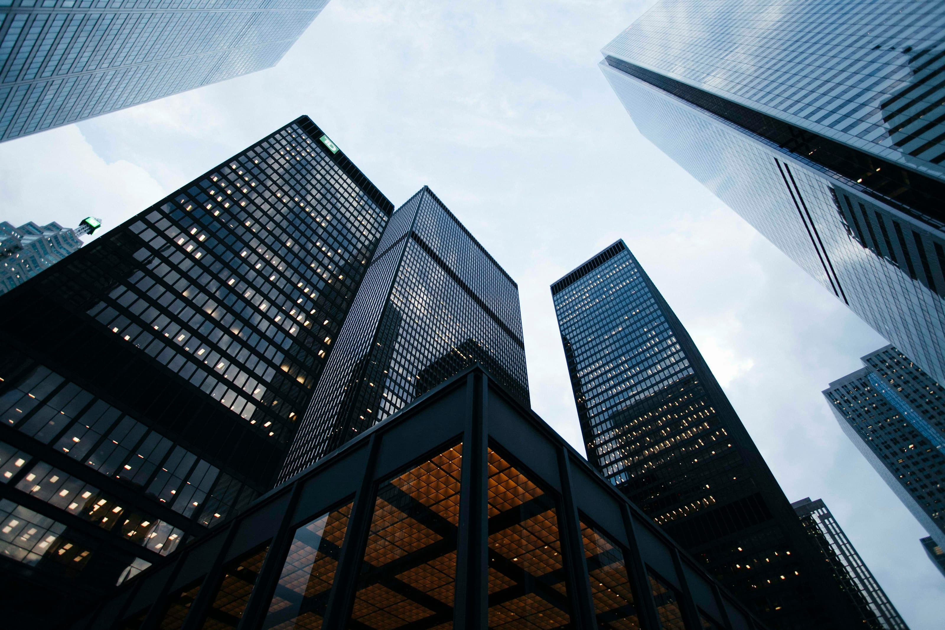 Glass office towers viewed upward against a steel blue sky